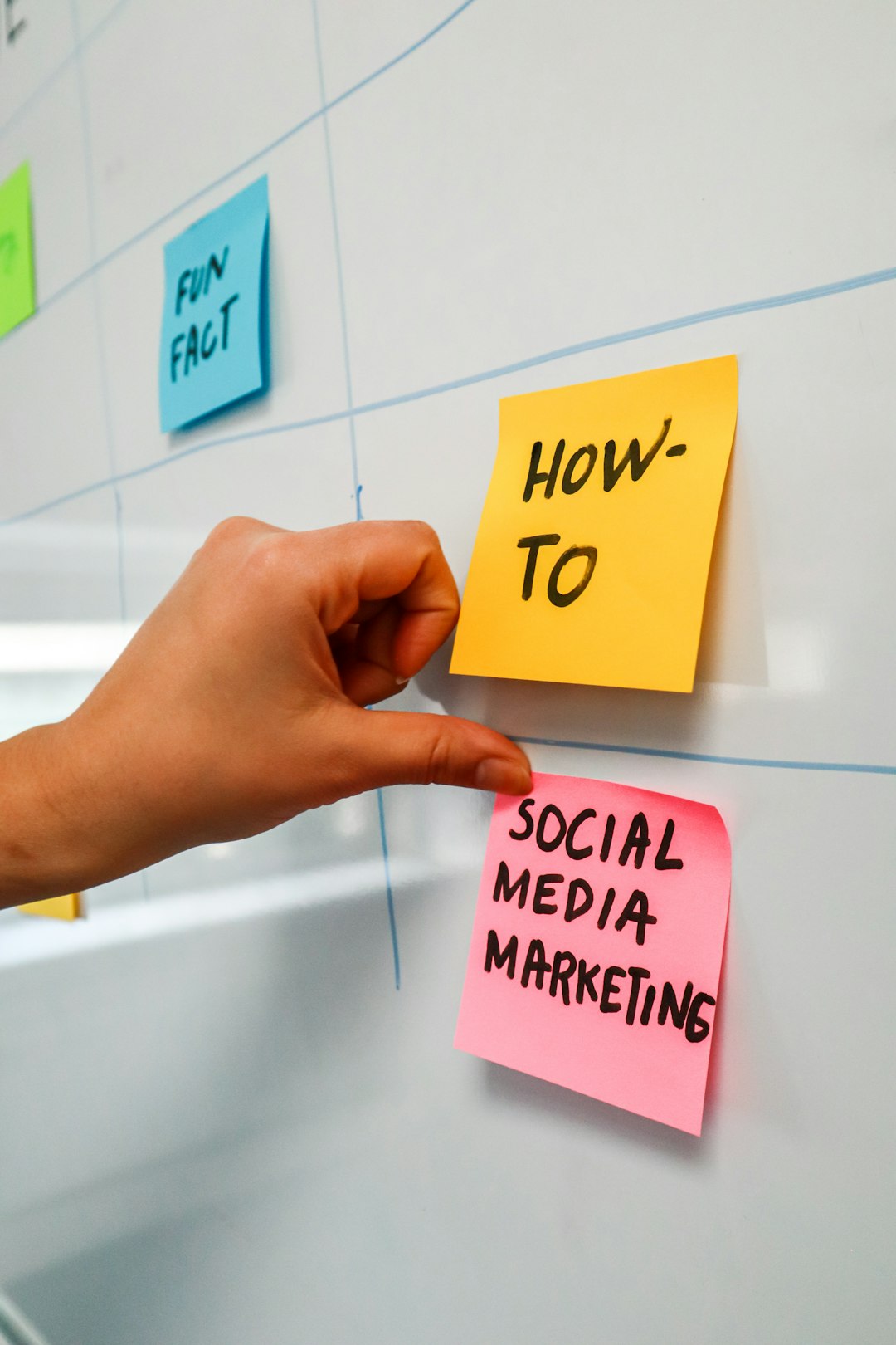 gallery-3 Person sticking a post-it on a white board with the words Social Media Marketing written on it